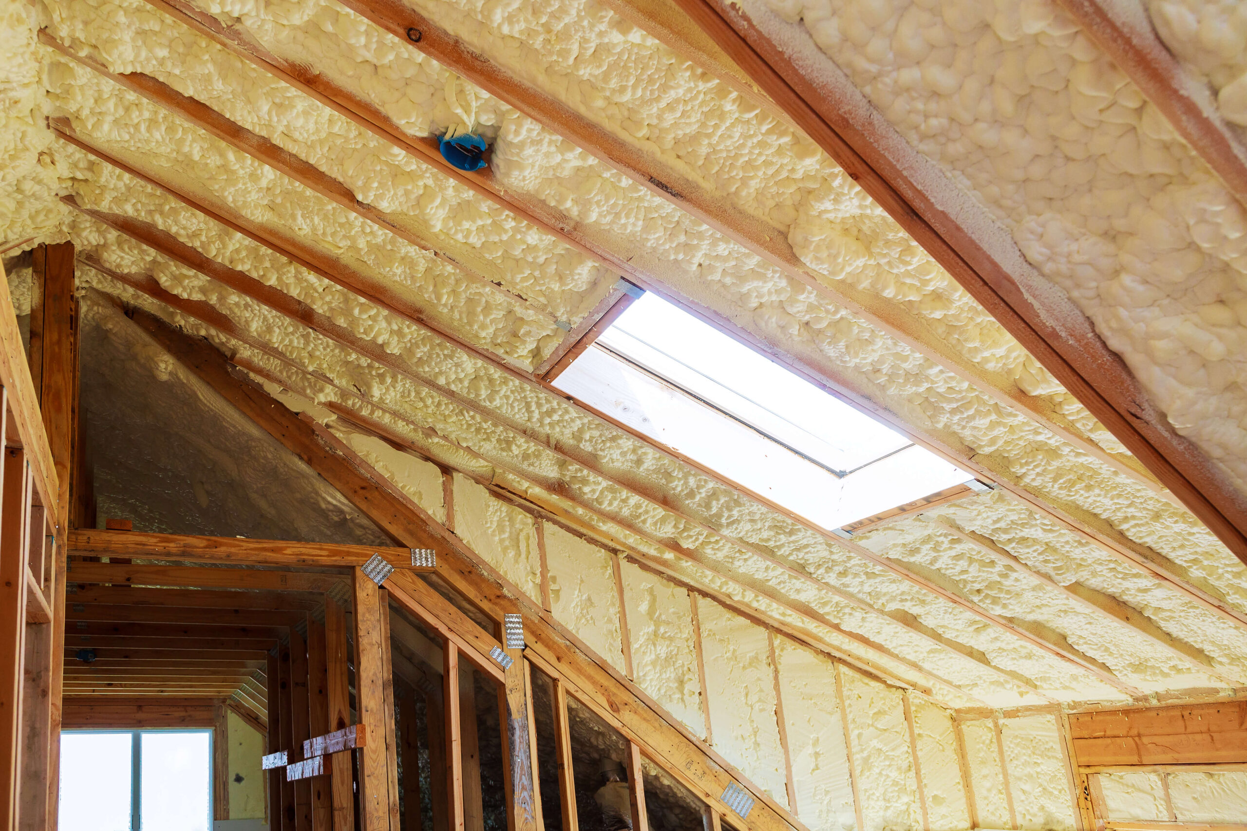 The attic of a home is being insulated with insulation.